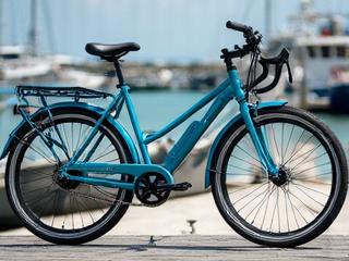 A contemporary fillet brazed commuter bike painted a striking metallic blue, parked by the Key West harbor.